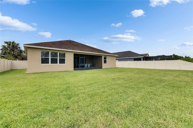 rear view of house featuring stucco siding and a sunroom
