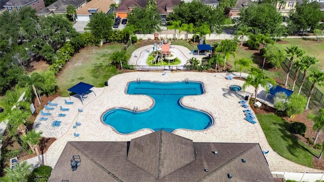 aerial view of property's location featuring a pool area and nearby suburban area