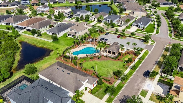 aerial view of residential area featuring a nearby body of water and a pool