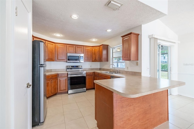 1426 Buckner Rd, Valrico, FL 33596 - kitchen with stainless steel appliances, a sink, a peninsula, light tile patterned floors, and brown cabinets