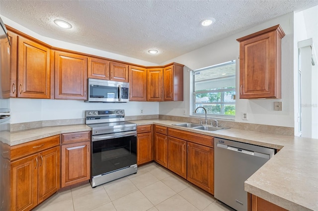 1426 Buckner Rd, Valrico, FL 33596 - kitchen with appliances with stainless steel finishes, a sink, brown cabinets, a textured ceiling, and recessed lighting