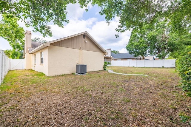 1426 Buckner Rd, Valrico, FL 33596 - rear view of house with cooling unit, a chimney, and stucco siding