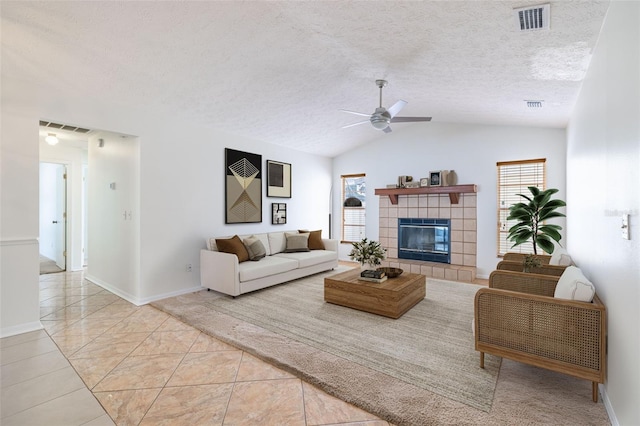 1426 Buckner Rd, Valrico, FL 33596 - living room with healthy amount of natural light, vaulted ceiling, a ceiling fan, a tiled fireplace, and a textured ceiling