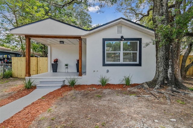 8704 N Brooks St, Tampa, FL 33604 - view of front facade featuring stucco siding, fence, and covered porch