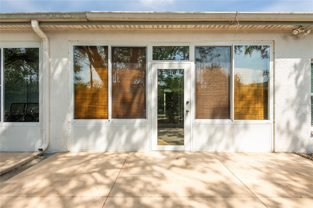 19025 Callaway Ct, Tampa, FL 33647 - doorway to property featuring stucco siding and a patio area