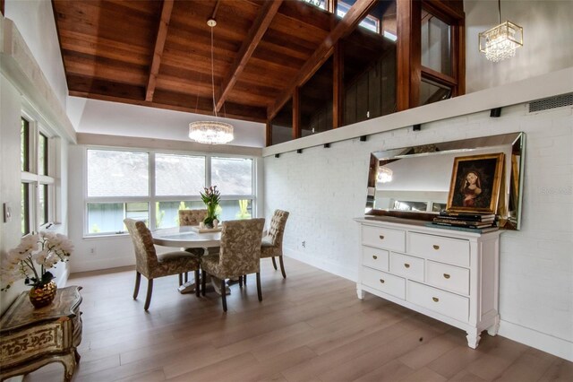 dining area featuring a chandelier, wooden ceiling, baseboards, wood finished floors, and beam ceiling
