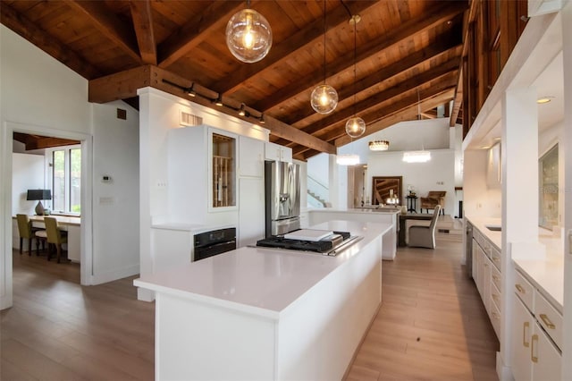 kitchen with wooden ceiling, a center island, stainless steel appliances, light wood-style flooring, and white cabinets