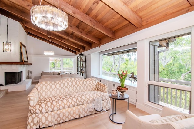 living area featuring wooden ceiling, a chandelier, light wood-style flooring, and a brick fireplace