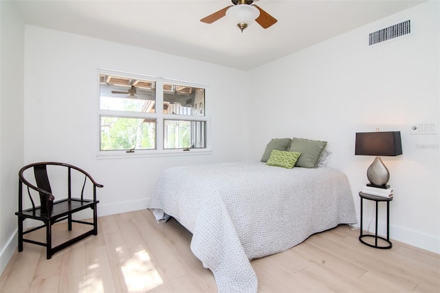 bedroom with light wood finished floors, baseboards, and a ceiling fan