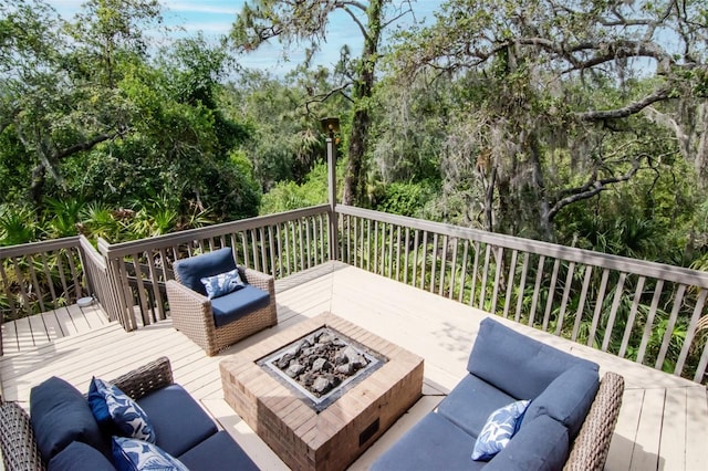 deck with an outdoor living space with a fire pit