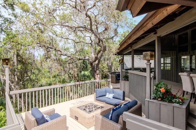 wooden terrace with an outdoor living space with a fire pit