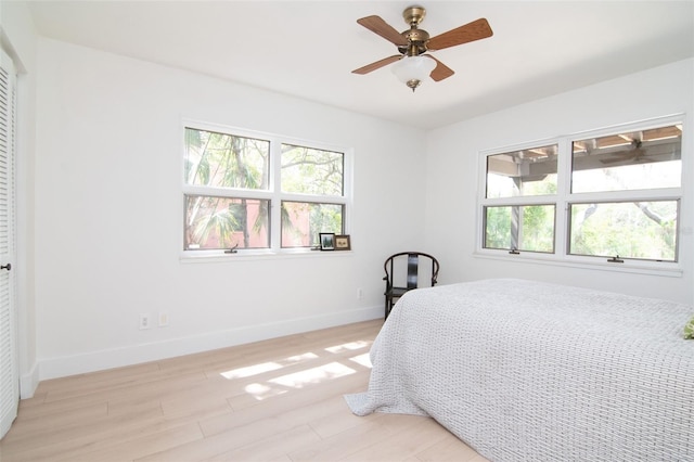 1296 Weybridge Ln, Dunedin, FL 34698 - bedroom with light wood finished floors, baseboards, and a ceiling fan