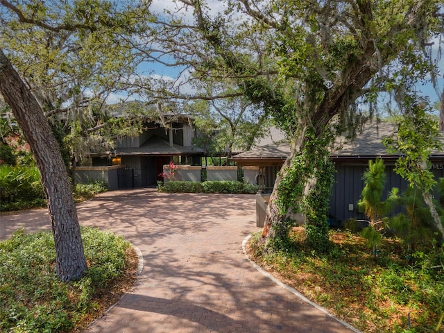 1296 Weybridge Ln, Dunedin, FL 34698 - view of front of house with board and batten siding, decorative driveway, and roof with shingles