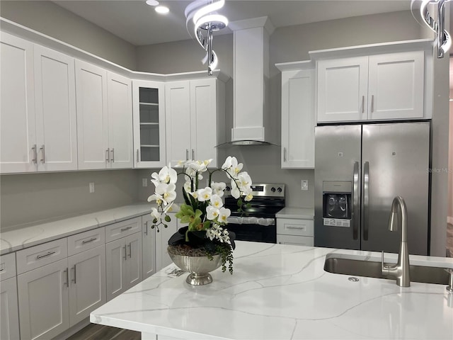 12308 Pittsfield Ave, Tampa, FL 33624 - kitchen featuring appliances with stainless steel finishes, wall chimney exhaust hood, a sink, white cabinetry, and glass insert cabinets