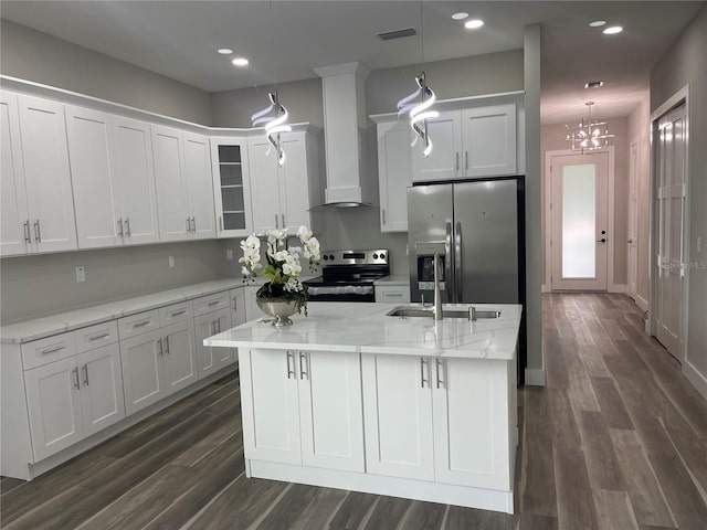 12308 Pittsfield Ave, Tampa, FL 33624 - kitchen featuring stainless steel appliances, wall chimney exhaust hood, white cabinets, dark wood-style floors, and an island with sink
