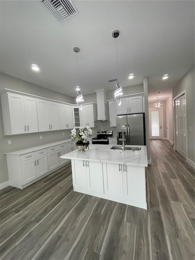 12308 Pittsfield Ave, Tampa, FL 33624 - kitchen with appliances with stainless steel finishes, wall chimney exhaust hood, white cabinets, dark wood-style floors, and baseboards