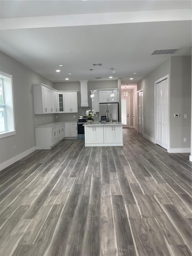 12308 Pittsfield Ave, Tampa, FL 33624 - kitchen with stainless steel appliances, open floor plan, dark wood finished floors, white cabinets, and a center island with sink