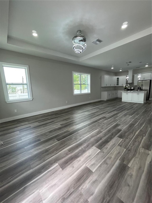 12308 Pittsfield Ave, Tampa, FL 33624 - unfurnished living room with a raised ceiling, baseboards, dark wood-style flooring, and recessed lighting