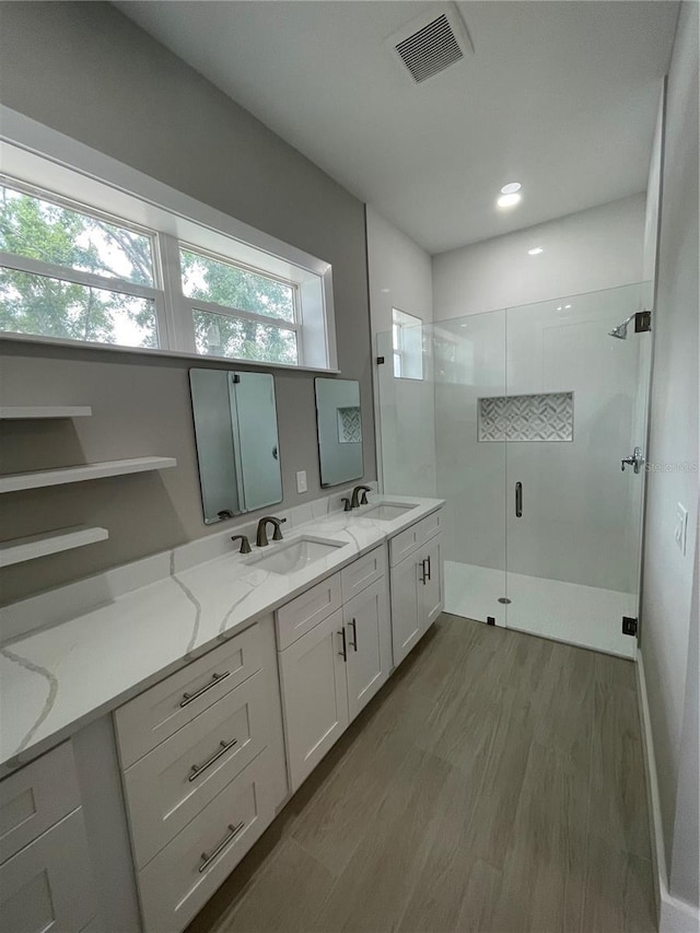 12308 Pittsfield Ave, Tampa, FL 33624 - full bathroom featuring a walk in shower, wood finished floors, and double vanity