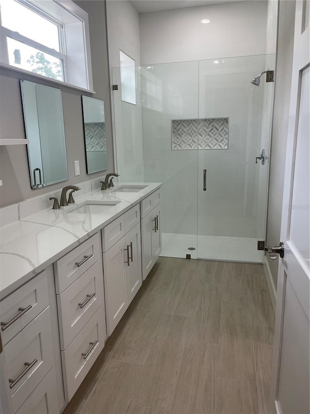 12308 Pittsfield Ave, Tampa, FL 33624 - full bath featuring a shower stall, double vanity, and wood finished floors