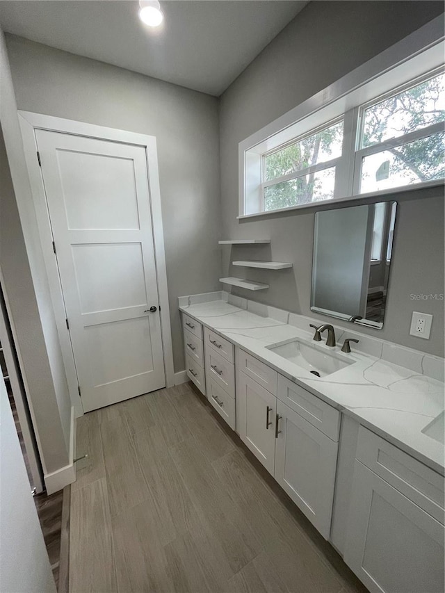 12308 Pittsfield Ave, Tampa, FL 33624 - bathroom with wood finished floors, vanity, and baseboards