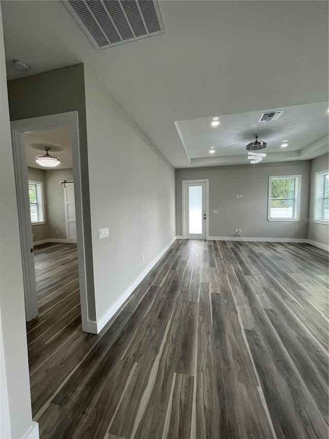 12308 Pittsfield Ave, Tampa, FL 33624 - spare room with baseboards, dark wood-style flooring, a tray ceiling, a smoke detector, and recessed lighting