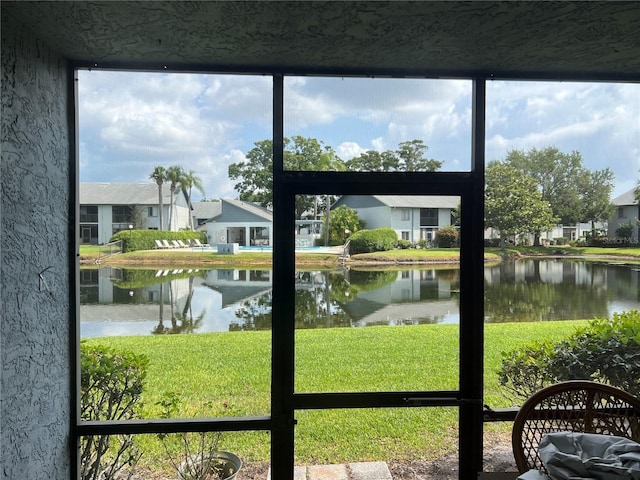 sunroom / solarium with a water view, plenty of natural light, and a residential view