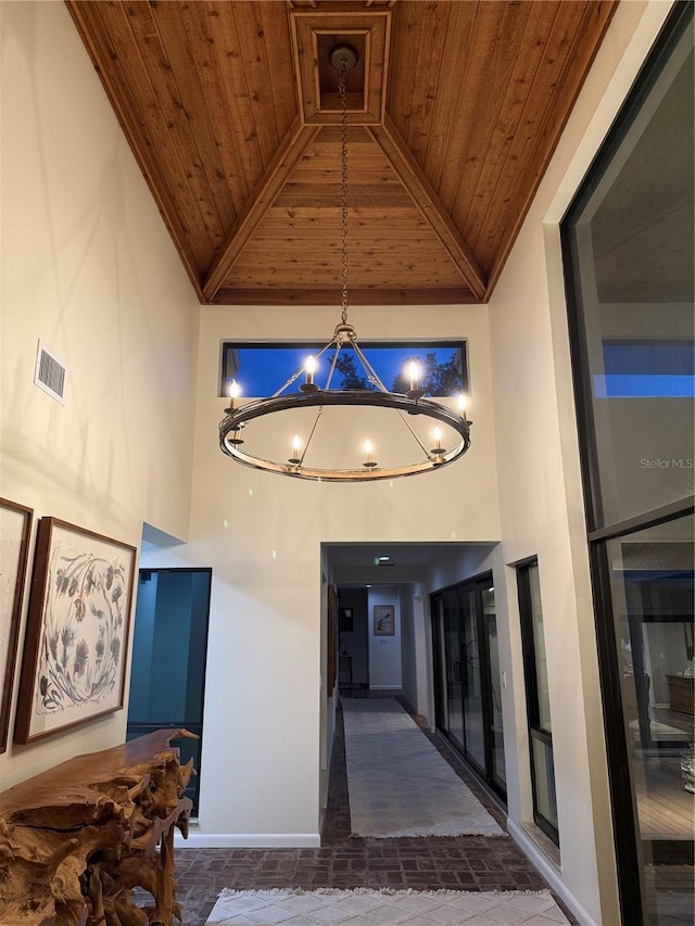 4009 Carrollwood Village Dr, Tampa, FL 33618 - corridor featuring wooden ceiling with exposed beams, baseboards, high vaulted ceiling, a chandelier, and stone finish floors