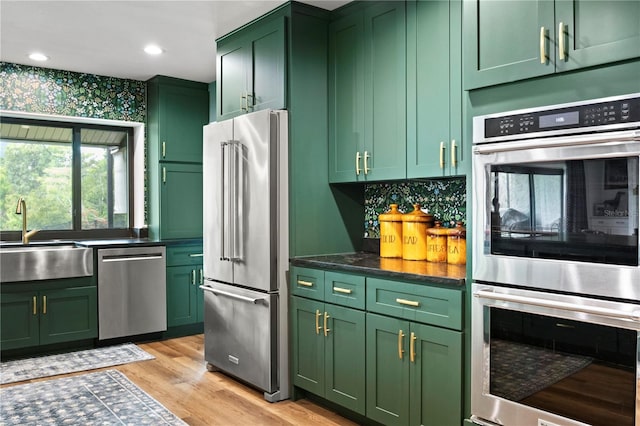 4009 Carrollwood Village Dr, Tampa, FL 33618 - kitchen featuring green cabinetry, appliances with stainless steel finishes, a sink, light wood-style flooring, and recessed lighting