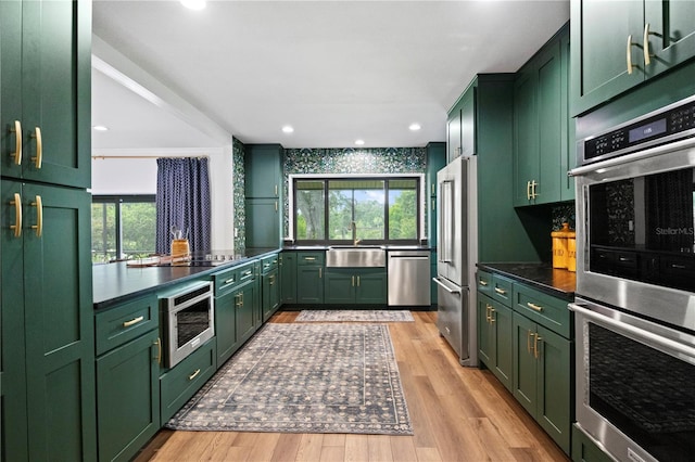 4009 Carrollwood Village Dr, Tampa, FL 33618 - kitchen with green cabinetry, appliances with stainless steel finishes, light wood-type flooring, a sink, and recessed lighting