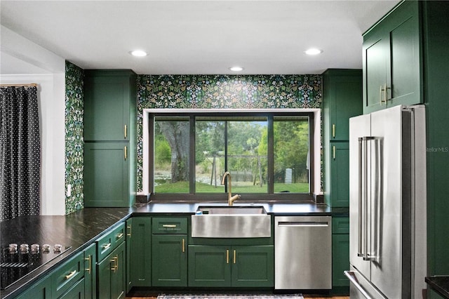 4009 Carrollwood Village Dr, Tampa, FL 33618 - kitchen with green cabinets, stainless steel appliances, a sink, wallpapered walls, and dark countertops