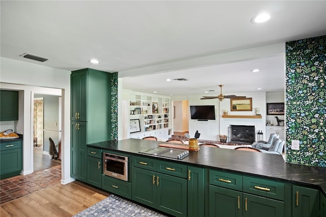 4009 Carrollwood Village Dr, Tampa, FL 33618 - kitchen featuring green cabinets, light wood-style floors, a ceiling fan, and electric cooktop