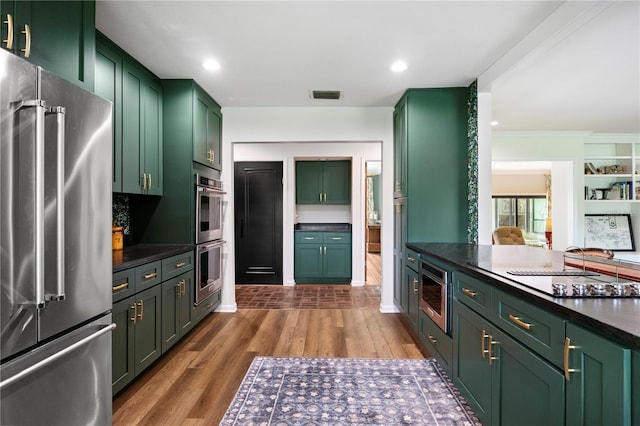 4009 Carrollwood Village Dr, Tampa, FL 33618 - kitchen with appliances with stainless steel finishes, green cabinets, dark wood-style floors, dark countertops, and recessed lighting
