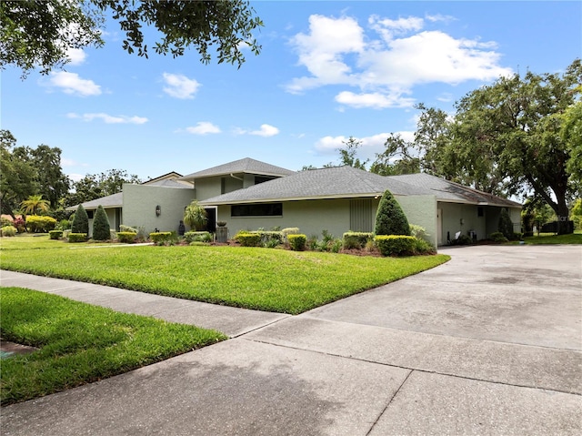 4009 Carrollwood Village Dr, Tampa, FL 33618 - view of front facade featuring a front lawn, concrete driveway, and stucco siding
