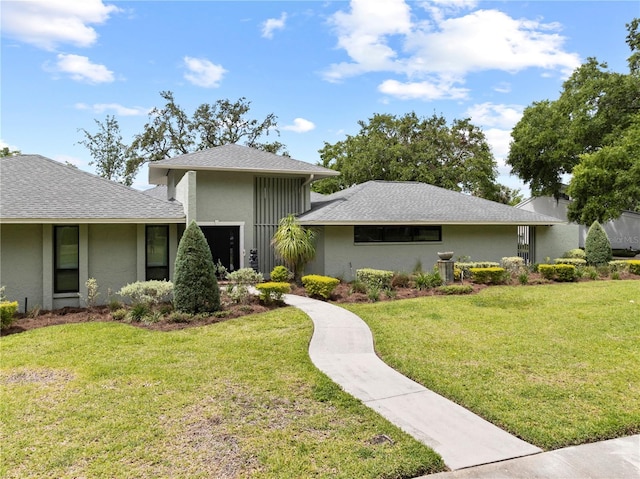 4009 Carrollwood Village Dr, Tampa, FL 33618 - view of front of house with a front lawn, stucco siding, and a shingled roof