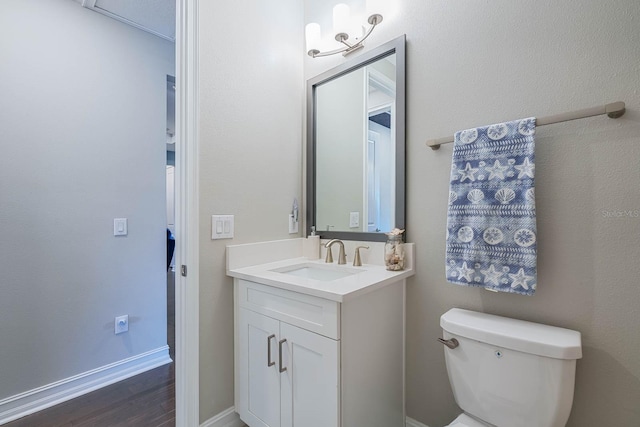 bathroom with vanity, toilet, and wood finished floors