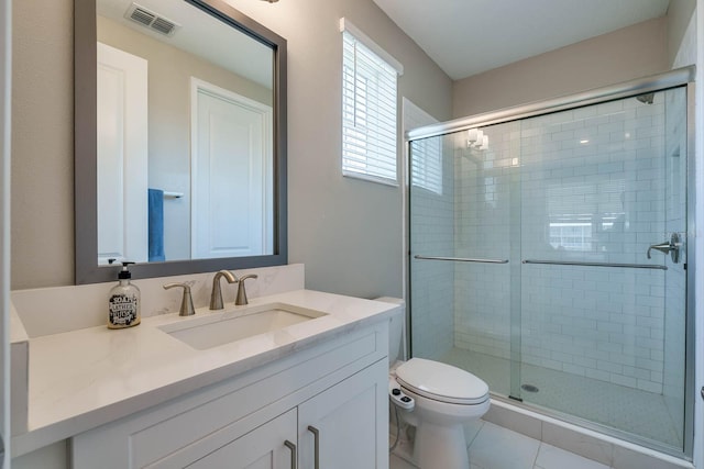 bathroom featuring a shower stall, toilet, vanity, and tile patterned flooring