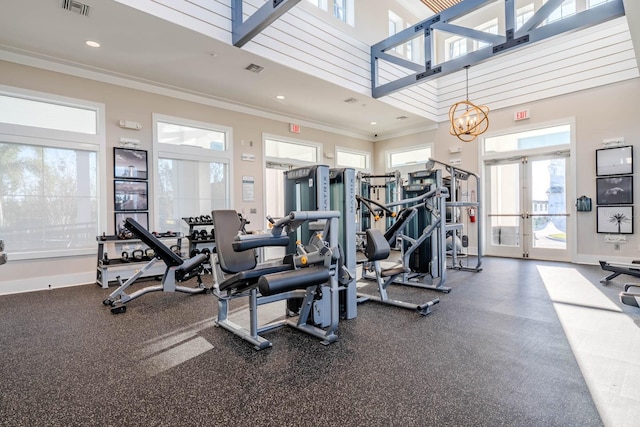 gym with ornamental molding, french doors, a chandelier, a towering ceiling, and recessed lighting