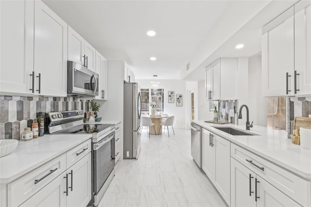 13934 Clubhouse Cir Unit 8, Tampa, FL 33618 - kitchen with stainless steel appliances, a sink, light marble finish floors, recessed lighting, and backsplash