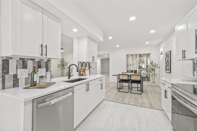 13934 Clubhouse Cir Unit 8, Tampa, FL 33618 - kitchen with appliances with stainless steel finishes, a sink, white cabinetry, recessed lighting, and light countertops