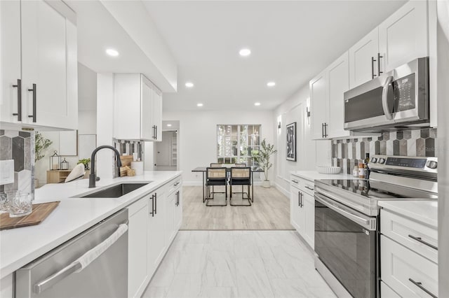 13934 Clubhouse Cir Unit 8, Tampa, FL 33618 - kitchen featuring stainless steel appliances, a sink, light countertops, tasteful backsplash, and recessed lighting