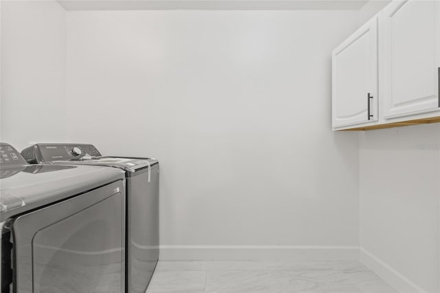 13934 Clubhouse Cir Unit 8, Tampa, FL 33618 - clothes washing area featuring washer and dryer, cabinet space, light marble finish floors, and baseboards