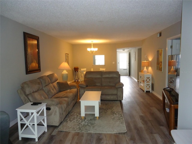 860 Virginia St Unit 308, Dunedin, FL 34698 - living room with wood finished floors, a chandelier, a textured ceiling, and baseboards