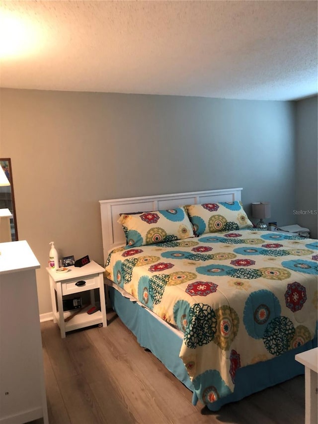 860 Virginia St Unit 308, Dunedin, FL 34698 - bedroom with wood finished floors and a textured ceiling