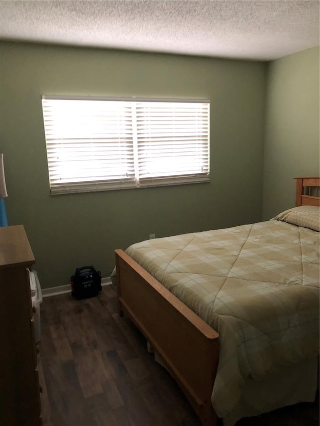 860 Virginia St Unit 308, Dunedin, FL 34698 - bedroom with multiple windows, dark wood-style floors, a textured ceiling, and baseboards