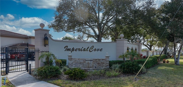 community / neighborhood sign with a gate and fence