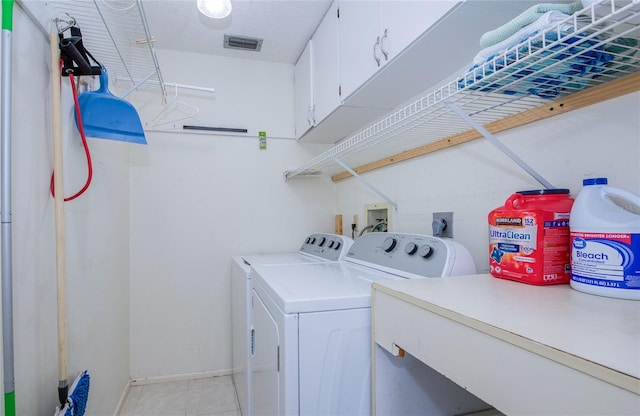 19029 US Highway 19 N Unit 31F, Clearwater, FL 33764 - laundry area with cabinet space, separate washer and dryer, light tile patterned floors, baseboards, and a textured ceiling