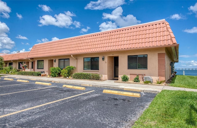 19029 US Highway 19 N Unit 31F, Clearwater, FL 33764 - view of front of property featuring a tiled roof, uncovered parking, and stucco siding