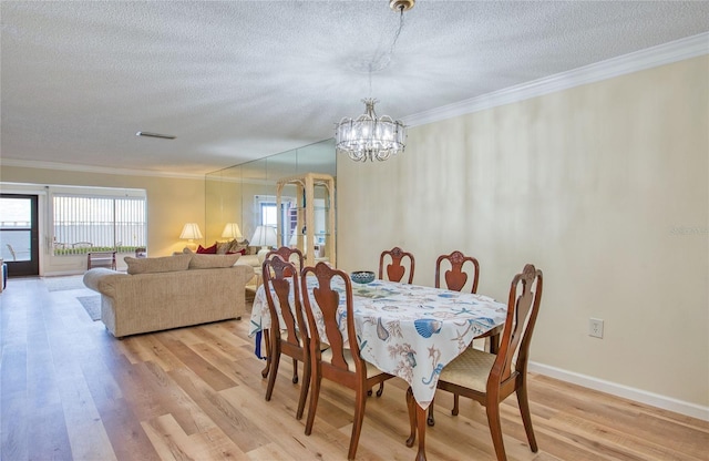 19029 US Highway 19 N Unit 31F, Clearwater, FL 33764 - dining area featuring crown molding, a textured ceiling, a chandelier, light wood-type flooring, and baseboards