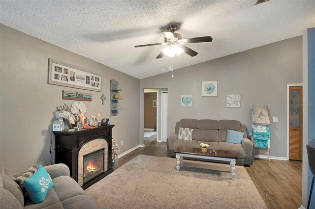 2816 Manor Hill Dr, Brandon, FL 33511 - living area featuring vaulted ceiling, a ceiling fan, wood finished floors, a textured ceiling, and a glass covered fireplace